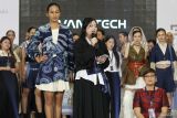 Mahasiswi Universitas Kristen Petra menjelaskan karya busana yang dikenakkan oleh model disampingnya saat Surabaya Fashion Parade bertemakan AVANTECH di Surabaya, Jawa Timur, Kamis (22/8/2024). Karya busana dari sejumlah mahasiswi Universitas Kristen Petra turut menyemarakkan gelaran peragaan busana yang berlangsung sampai 25 Agustus 2024. Antara Jatim/Didik Suhartono/um