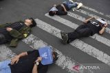 Pengunjuk rasa dari Aliansi Mahasiswa dan Masyarakat Tasikmalaya melakukan aksi teatrikal tidur terlentang di jalan Kota Tasikmalaya, Jawa Barat, Kamis (22/8/2024). Aksi tidur terlentang yang menutup jalan itu sebagai bentuk penolakan revisi UU Pilkada oleh DPR. ANTARA FOTO/Adeng Bustomi/agr