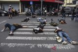 Pengunjuk rasa dari Aliansi Mahasiswa dan Masyarakat Tasikmalaya melakukan aksi teatrikal tidur terlentang di jalan Kota Tasikmalaya, Jawa Barat, Kamis (22/8/2024). Aksi tidur terlentang yang menutup jalan itu sebagai bentuk penolakan revisi UU Pilkada oleh DPR. ANTARA FOTO/Adeng Bustomi/agr