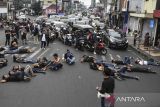 Pengunjuk rasa dari Aliansi Mahasiswa dan Masyarakat Tasikmalaya melakukan aksi teatrikal tidur terlentang di jalan Kota Tasikmalaya, Jawa Barat, Kamis (22/8/2024). Aksi tidur terlentang yang menutup jalan itu sebagai bentuk penolakan revisi UU Pilkada oleh DPR. ANTARA FOTO/Adeng Bustomi/agr