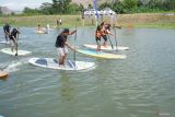 Peserta adu ketangkasan menggunakan papan paddle dalam kegiatan Stand Up Paddle for Fun yang digelar komunitas GesperTa di Dam Pacar, Tulungagung, Minggu (25/8/2024). Olahraga papan dayung berdiri atau stand up paddling itu digelar pertama kali di Tulungagung dalam rangka memeriahkan HUT RI sekaligus mengenalkan olahraga paddling spot sungai di kalangan anak dan remaja daerah itu. Antara Jatim/Destyan Sujarwoko/um