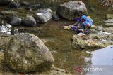 Warga mencuci baju di Sungai Cipamutih, Desa Gunung Tanjung, Kabupaten Tasikmalaya, Jawa Barat, Senin (26/8/2024). Sebanyak 70 Kepala Keluarga (KK) terpaksa mandi, cuci, dan kakus di sungai akibat kesulitan air bersih sejak tiga bulan terakhir karena musim kemarau. ANTARA FOTO/Adeng Bustomi/agr