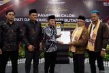 Ketua KPU Blitar Sugino (tiga kiri) didampingi jajarannya menyerahkan tanda terima penyerahan berkas pendaftaran kepada bakal calon bupati (Bacabup) Blitar Rijanto (dua kanan) saat pembukaan pendaftaran peserta Pilkada Serentak 2024 di kantor KPU Blitar, Jawa Timur, Selasa (27/8/2024). Pasangan Rijanto-Beky yang diusung oleh koalisasi partai PDIP, PAN, dan Nasdem tersebut merupakan calon peserta pilkada pertama yang mendaftarkan diri di KPU Blitar. Antara Jatim/Irfan Anshori/um