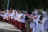 Sejumlah pelajar menyaksikan kirab obor api PON XXI di Kota Sabang, Aceh, Selasa (27/8/2024). Api abadi PON XXI Aceh-Sumut bersumber dari Gunung Merapi Jaboi yang kemudian diserahkan oleh Pemerintah Kota Sabang kepada pasukan Panitia Besar PON XXI wilayah Aceh untuk dilakukan kirab mengelilingi 23 kabupaten/kota di Aceh. ANTARA FOTO/Khalis Surry