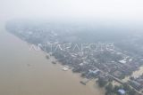 Foto udara permukiman warga di Muara Sabak Timur yang diselimuti kabut asap akibat kebakaran hutan dan lahan (karhutla) di Tanjung Jabung Timur, Jambi, Selasa (27/8/2024). Sebagian wilayah di kabupaten itu mulai terdampak kabut asap akibat karhutla yang terjadi di daerah itu sejak tiga hari terakhir yang mengakibatkan terbatasnya jarak pandang dan buruknya kualitas udara sehingga mengganggu kesehatan. ANTARA FOTO/Wahdi Septiawan/aww.