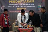 Ketua KPU Kota Blitar Rangga Bisma Aditya (dua kanan) didampingi Ketua Bawaslu Kota Blitar Roma Hudi Arif (kanan) menyaksikan penandatanganan berkas pernyataan visi misi dan program oleh pasangan bakal calon walikota (bacawalikota) yang diusung oleh partai PDIP, PPP, Gerindra, dan Golkar, Bambang Rianto (dua kiri) serta pasangannya Bayu Setyo Kuncoro (kiri) saat penerimaan pendaftaran pasangan bacawalikota peserta pemilukada serentak 2024 di Kantor KPU Kota Blitar, Jawa Timur, Rabu (28/8/2024). Dihari kedua pembukaan pendafatran, KPU Kota Blitar menerima sekaligus melakukan verifikasi terhadap dua pasangan bakal calon yang mendaftar, yakni pasangan Bambang Rijanto-Bayu Setyo Kuncoro, dan Syauqul Muhibbin-Elim Tyu Samba. ANTARA Jatim/Irfan Anshori/mas