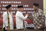 Ketua Komisi Pemilihan Umum (KPU) Provinsi Kalimantan Timur Fahmi Idris (kanan) berjabat tangan dengan bakal calon Gubernur Kalimantan Timur Isran Noor (kedua kiri) disaksikan bakal calon Wakil Gubernur Hadi Mulyadi (kiri) saat mendaftarkan diri sebagai peserta Pilgub 2024 di KPU Provinsi Kalimantan Timur, di Samarinda, Rabu (28/8/2024). Isran Noor dan Hadi Mulyadi resmi mendaftarkan diri sebagai peserta pencalonan Pilgub Kaltim 2024. Antara Kaltim/M Risyal Hidayat