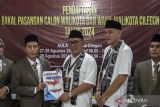 Pasangan Helldy-Alawi mendaftar ke KPU Kota Cilegon. Ketua KPU Kota Cilegon Patchurrohman (kedua kiri) menerima berkas pendaftaran pencalonan pasangan bakal calon Walikota dan Wakil Walikota Cilegon Helldy Agustian (tengah) dan Alawi Mahmud (kedua kanan) di kantor Komisi Pemilihan Umum Kota Cilegon, Banten, Rabu (28/8/2024). Helldy Agustian yang merupakan Walikota petahana serta berpasangan dengan Alawi Mahmud tersebut diusung Partai Gerinda, PAN, PKB, PSI, dan PBB, dan telah resmi mendaftarkan diri sebagai calon Walikota dan Walikota kota Cilegon pada Pilkada 2024 mendatang. ANTARA FOTO/Angga Budhiyanto/gp