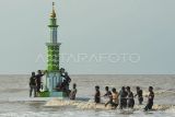 Warga menarik menara adat ke tepi Pantai Babussalam menjelang pelaksanaan tradisi mandi safar 2024 di Air Hitam Laut, Tanjung Jabung Timur, Jambi, Selasa (27/8/2024). Kegiatan itu bagian dalam rangkaian persiapan menjelang puncak pelaksanaan tradisi mandi safar yang dilaksanakan setiap Rabu terakhir di bulan safar atau jatuh pada 28 Agustus 2024. ANTARA FOTO/Wahdi Septiawan/Spt.
