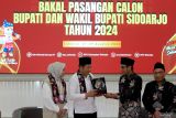 Ketua KPU Sidoarjo Fauzan Adhim (kedua kanan) anggota KPU Sidoarjo, Divisi Teknis Penyelenggara Haidar Munjid (kanan) menyerahkan maskot Pilkada kepada bakal calon Bupati Sidoarjo Subandi (kedua kiri) dan bakal calon Wakil Bupati Mimik Idayana (kiri) saat mendaftarkan di KPU Sidoarjo, Jawa Timur, Kamis (29/8/2024). Pasangan Subandi-Mimik Idayana mendaftarkan diri sebagai bakal calon Bupati dan Wakil Bupati Sidoarjo yang diusung Partai Gerindra, Golkar, Demokrat serta beberapa parpol dari non-parlemen. Antara Jatim/Umarul Faruq/mas