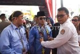 Sekretaris Komisi Pemilihan Umum (KPU) Provinsi Kalimantan Timur Aliuk (kanan) mengalungkan syal manik khas Dayak kepada bakal calon Gubernur Kaltim Rudy Mas'ud (kedua kanan) disaksikan bakal calon Wakil Gubernur Seno Aji (kiri) saat tiba di KPU Provinsi Kaltim, di Samarinda, Kamis (29/8/2024). Pasangan Rudy Mas'ud-Seno Aji resmi mendaftarkan diri sebagai peserta Pilkada Kaltim 2024 dengan dukungan dari partai politik yang tergabung dalam Koalisi Indonesia Maju (KIM) Plus. Antara Kaltim/M Risyal Hidayat