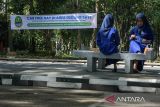 Pelajar beristirahat di area parkir Gedung Sate, Bandung, Jawa Barat, Kamis (29/8/2024). Pemerintah Provinsi Jawa Barat mulai menerapkan kebijakan Car Free Day Zero Emision dengan melarang penggunaan kendaraan BBM selain kendaraan listrik seperti mobil, motor, dan sepeda listrik setiap Kamis dan Jumat sebagai program menjaga lingkungan serta menggalakkan penggunaan transportasi umum. ANTARA FOTO/Novrian Arbi/agr