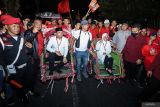 Pasangan bakal calon Gubernur dan Wakil Gubernur Jawa Timur Tri Rismaharini (ketujuh kanan) dan KH Zahrul Azhar Asumta (ketiga kiri) duduk di atas becak dengan diantar pendukungnya saat pendaftaran di Kantor KPU Provinsi Jawa Timur, Surabaya, Jawa Timur, Kamis (29/8/2024). Pasangan Tri Rismaharini dan KH Zahrul Azhar Asumta mendaftarkan diri sebagai peserta Pilgub Jatim 2024 dengan dukungan dari partai PDIP dan Hanura. Antara Jatim/Rizal Hanafi/um