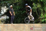 Pelatih M Nur Azmi Rasyad (kiri) mendampingi atlet BMX Kalbar Tarigas (kanan) yang diasuhnya saat menggelar latihan persiapan untuk PON XXI 2024 di Taman Digulis, Pontianak, Kalimantan Barat, Sabtu (31/8/2024). Atlet sepeda BMX Kalimantan Barat Tarigas yang diasuh oleh Pelatih Muhammad Nur Azmi Rasyad akan bertanding dalam PON XXI Aceh Sumut 2024 pada September mendatang. ANTARA FOTO/Jessica Wuysang