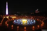 Umat Buddha berjalan melintasi ribuan lilin dan lampu yang menyala di Tugu Pahlawan, Surabaya, Jawa Timur, Sabtu (31/8/2024). Sekitar 10.000 lilin dan lampu yang dinyalakan itu merupakan kegiatan umat Budha untuk memperingati Hari Asadha 2024. Antara Jatim/Didik Suhartono/um