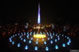 Umat Buddha berjalan melintasi ribuan lilin dan lampu yang menyala di Tugu Pahlawan, Surabaya, Jawa Timur, Sabtu (31/8/2024). Sekitar 10.000 lilin dan lampu yang dinyalakan itu merupakan kegiatan umat Budha untuk memperingati Hari Asadha 2024. Antara Jatim/Didik Suhartono/um