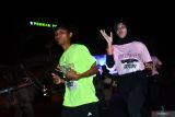 Sejumlah pelari mengikuti lomba lari glow run 5K saat melintas di kawasan Alun-alun Ponorogo Jawa Timur, Sabtu (31/8/2024). Lomba lari sejauh lima kilometer tersebut diikuti seribu lebih peserta dari Ponorogo dan sekitarnya. Antara Jatim/Siswowidodo/um