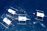 Foto aerial sejumlah wisatawan melihat Hiu Paus (Rhincodon Typus) dengan menaiki perahu di objek wisata Hiu Paus Desa Botubarani, Kabupaten Bone Bolango, Gorontalo, Sabtu (31/8/2024). Dinas Pariwisata Provinsi Gorontalo menggelar Festival Hiu Paus untuk pertama kalinya sebagai sarana promosi ekosistem pariwisata yang terintegrasi dengan kelestarian lingkungan berkelanjutan. ANTARA FOTO/Adiwinata Solihin