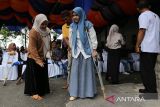 Seorang penyandang disabilitas mencoba berjalan dengan dibantu keluarganya  seusai pemasangan kaki palsu di PT Angkasa Pura-II, kabupaten Aceh Besar, Aceh, Selasa (3/9/2024).  PT Angkasa Pura II Bandara Internasional Blang Bintang  bersama pemerintah Aceh dan Kick Andy Foundation melalui program kemerdekaan tanpa batas membangun inklusifitas dan kesetaraan di daerah itu, memberikan bantuan sebanyak 49 kaki palsu kepada  penyandang disabilitas di lima kabupaten provinsi Aceh. ANTARA FOTO/Ampelsa.