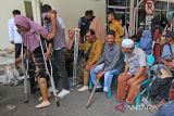 Seorang penyandang disabilitas mencoba berjalan dengan dibantu keluarganya  seusai pemasangan kaki palsu di PT Angkasa Pura-II, kabupaten Aceh Besar, Aceh, Selasa (3/9/2024).  PT Angkasa Pura II Bandara Internasional Blang Bintang  bersama pemerintah Aceh dan Kick Andy Foundation melalui program kemerdekaan tanpa batas membangun inklusifitas dan kesetaraan di daerah itu, memberikan bantuan sebanyak 49 kaki palsu kepada  penyandang disabilitas di lima kabupaten provinsi Aceh. ANTARA FOTO/Ampelsa.