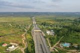 Foto udara suasana jalan tol Samarinda-Balikpapan yang terlihat dari kawasan Palaran, Samarinda, Kalimantan Timur, Selasa (3/9/2024). Menurut laman Badan Pengatur Jalan Tol bpjt.pu.go.id, pembangunan jalan tol Samarinda-Balikpapan yang pertama di Kalimantan sepanjang 99,35 kilometer dengan dana investasi mencapai Rp9,9 triliun disebut paling sepi di Indonesia. Antara Kaltim/M Risyal Hidayat