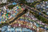 Foto udara sejumlah kendaraan melintas di sekitar Kampung Warna-warni Jodipan, Malang, Jawa Timur, Rabu (4/9/2024). Jumlah desa mandiri di Jawa Timur meningkat 43,54 persen dari tahun sebelumnya yakni dari 2.800 desa di tahun 2023 menjadi 4.019 desa di tahun 2024 dan menjadi yang tertinggi di Indonesia. Antara Jatim/Muhammad Mada/um