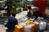 Warga mengisi jerikan dengan air bersih yang didistribusikan Badan Penanggulangan Bencana Daerah (BPBD) di Desa Duri Slahung, Ponorogo, Jawa Timur, Kamis (5/9/2024). BPBD Ponorogo mendistribusikan air bersih ke sembilan desa yang mengalami kesulitan mendapatkan air bersih akibat musim kemarau. Antara Jatim/Siswowidodo/mas.