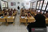 Sejumlah murid sekolah mengikuti proses belajar mengajar menjelang pemberlakukan sistem belajar daring dan luring di Sekolah Menengah Pertama (SMP)  I Banda Aceh, Aceh, Jumat (6/9/2024).  Pemeritah Aceh menetapkan sistem belajar mengajar  secara daring dan luring di sejumlah sekolah daerah itu terhitung  tanggal 7 hingga 23 September  2024 untuk menghindari  kemacetan lalulintas dan penumpukan massa selama berlangsung pelaksanaan PON XXI Aceh-Sumut 2024. ANTARA FOTO/Ampelsa.