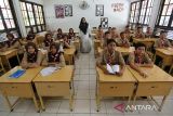 Sejumlah murid sekolah mengikuti proses belajar mengajar menjelang pemberlakukan sistem belajar daring dan luring di Sekolah Menengah Pertama (SMP)  I Banda Aceh, Aceh, Jumat (6/9/2024).  Pemeritah Aceh menetapkan sistem belajar mengajar  secara daring dan luring di sejumlah sekolah daerah itu terhitung  tanggal 7 hingga 23 September  2024 untuk menghindari  kemacetan lalulintas dan penumpukan massa selama berlangsung pelaksanaan PON XXI Aceh-Sumut 2024. ANTARA FOTO/Ampelsa.