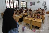 Sejumlah murid sekolah mengikuti proses belajar mengajar menjelang pemberlakukan sistem belajar daring dan luring di Sekolah Menengah Pertama (SMP)  I Banda Aceh, Aceh, Jumat (6/9/2024).  Pemeritah Aceh menetapkan sistem belajar mengajar  secara daring dan luring di sejumlah sekolah daerah itu terhitung  tanggal 7 hingga 23 September  2024 untuk menghindari  kemacetan lalulintas dan penumpukan massa selama berlangsung pelaksanaan PON XXI Aceh-Sumut 2024. ANTARA FOTO/Ampelsa.