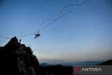 Pegiat olahraga ekstrem terjatuh saat berjalan di atas tali webbing pada acara Indonesia Highline Festival di Tebing Hawu, Padalarang, Kabupaten Bandung Barat, Jawa Barat, Sabtu (7/9/2024). Indonesia Highline Festival 2024 yang diikuti oleh pegiat olahraga highline dari berbagai negara seperti Indonesia, Argentina, India, Australia, dan Austria tersebut bertujuan untuk mempromosikan olahraga highline kepada masyarakat luas serta sebagai upaya melestarikan Kawasan Konservasi Karst Citatah. ANTARA FOTO/Raisan Al Farisi/agr
