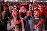 Warga menyanyikan lagu Indonesia Raya saat menyaksikan pertandingan putaran ketiga kualifikasi Piala Dunia 2026 Zona Asia antara Timnas Indonesia melawan Australia di Surabaya Expo Center, Surabaya, Jawa Timur, Selasa (10/9/2024). Pemerintah setempat menyelenggarakan nonton bareng guna memfasilitasi antusiasme masyarakat untuk mendukung Timnas Indonesia yang berlaga pada pertandingan tersebut. ANTARA Jatim/Rizal Hanafi/mas.