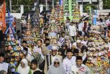 Umat Islam mengikuti tradisi Ngarak Perahu di kawasan Pasar Lama, Tangerang, Banten, Senin (16/9/2024). Tradisi mengarak perahu dan pembagian hasil bumi yang telah dilakukan sejak tahun 1939 tersebut dalam rangka memperingati Maulid Nabi Muhammad SAW. ANTARA FOTO/Sulthony Hasanuddin/nym/gp