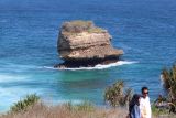 Dua orang pengunjung menikmati pemandangan alam di Pantai Pudak, Kabupaten Blitar, Jawa Timur, Minggu (15/9/2024). Wisata yang baru dibuka pada awal tahun 2024 seiring dibangunnya Jalan Lintas Selatan Jawa tersebut ramai pengunjung pada libur panjang akhir pekan yang bertepatan dengan libur peringatan Maulid Nabi Muhammad SAW. ANTARA Jatim/Prasetia Fauzani/mas.