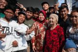 Mantan Menteri Sosial yang juga merupakan bakal calon Gubernur Jawa Timur 2024 Tri Rismaharini (keempat kanan) berfoto bersama warga saat Grebeg Maulid di Surabaya, Jawa Timur, Senin (16/9/2024). Kehadirannya itu untuk memberangkatkan pawai dan arak-arakan sejumlah gunungan berisi hasil bumi yang digelar untuk merayakan hari lahir Nabi Muhammad SAW. ANTARA Jatim/Didik Suhartono/mas.