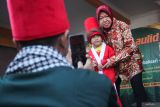 Mantan Menteri Sosial yang juga merupakan bakal calon Gubernur Jawa Timur 2024 Tri Rismaharini (kanan) berfoto bersama seorang anak saat Grebeg Maulid di Surabaya, Jawa Timur, Senin (16/9/2024). Kehadirannya itu untuk memberangkatkan pawai dan arak-arakan sejumlah gunungan berisi hasil bumi yang digelar untuk merayakan hari lahir Nabi Muhammad SAW. ANTARA Jatim/Didik Suhartono/mas.