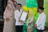 Direktur Operasional MURI Yusuf Ngadri (kedua kiri) menyerahkan piagam rekor dunia MURI kepada Direktur PT Pharos Indonesia dr. Mariani Leman (kedua kanan) di saksikan Plt Bupati Sidoarjo Subandi (kanan) saat pemecahan rekor test kolesterol gratis di Masjid Agung Sidoarjo, Jawa Timur, Rabu (18/0/2024). Sebanyak 2.500 Jamaah mengikuti pemecahan rekor Museum Rekor Dunia Indonesia (MURI) test kolesterol gratis. Antara Jatim/Umarul Faruq