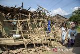 Warga melintasi rumah yang rusak pascagempa bumi di Desa Cibeureum, Kertasari, Kabupaten Bandung, Jawa Barat, Rabu (18/9/2024). Menurut data sementara BPBD Provinsi Jawa Barat, gempa berkekuatan Magnitudo 5,0 tersebut mengakibatkan 8 unit rumah, 2 fasilitas kesehatan, 1 sarana pendidikan, dan 1 tempat ibadah mengalami kerusakan. ANTARA FOTO/Novrian Arbi/agr