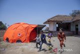 Anak-anak berlari di dekat tenda pengungsian pascagempa bumi di Desa Barusari, Pasirwangi, Kabupaten Garut, Jawa Barat, Kamis (19/9/2024). Pemerintah Kabupaten Garut menetapkan status tanggap darurat bencana selama 14 hari ke depan atas bencana gempa bumi bermagnitudo 5.0 yang mengakibatkan sebanyak 1.195 rumah, 30 fasilitas pendidikan dan 20 rumah ibadah mengalami kerusakan. ANTARA FOTO/Abdan Syakura/agr
