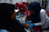 Petugas Palang Merah Indonesia (PMI) melakukan pengambilan darah dari penderma di sektretariat Unit Transfusi Darah PMI Kota Madiun, Jawa Timur, Kamis (19/9/2024). Kegiatan donor darah tersebut dalam rangka peringatan Hari PMI. Antara Jatim/Siswowidodo/um