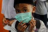 Pembagian masker dampak kebakaran TPSA Bagendung. Seorang siswa meggunakan masker di SD Negeri 1 Lebak Gebang, Kota Cilegon, Banten, Jumat (20/9/2024). Dinkes Kota Cilegon membagikan 1.000 masker kepada masyarakat yang tinggal dekat dengan TPSA Bagendung untuk mencegah terjangkitnya penyakit Infeksi Saluran Pernapasan Akut (ISPA) akibat asap kebakaran sampah yang masih terjadi hingga saat ini. ANTARA FOTO/Muhammad Bagus Khoirunas/ANTARA FOTO/Muhammad Bagus Khoirunas (ANTARA FOTO/Muhammad Bagus Khoirunas)