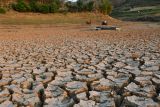 Warga mengendarai sepeda motor melintasi areal Waduk Bendo dengan sebagian dasar waduknya yang mengering di Kabupaten Ponorogo, Jawa Timur, Jumat (20/9/2024). Waduk yang memiliki kapasitas 43 juta meter kubik air tersebut sejak sekitar sebulan terakir airnya terus menyusut dan sebagian daerah genangan sudah mulai mengering akibat musim kemarau. Antara Jatim/Siswowidodo/um