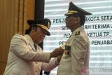 Pj Gubernur Banten Al Muktabar (kiri) menyematkan tanda jabatan kepada Pj Wali Kota Serang Nanang Saefudin (kanan) saat pelantikan di Pendopo Gubernur Provinsi Banten, Kawasan Pusat Pemerintahan Provinsi Banten (KP3B), Kota Serang, Banten, Sabtu (21/9/2024). Nanang Saefudin yang sebelumnya menjabat sebagai Sekretaris Daerah (Sekda) Kota Serang resmi dilantik sebagai Pj Wali Kota Serang menggantikan Yedi Rahmat. ANTARA FOTO/Angga Budhiyanto/gp