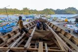 Pekerja menyelesaikan pembuatan kapal nelayan tradisional di kawasan pantai Sendangbiru, Malang, Jawa Timur, Sabtu (21/9/2024). Pembuatan kapal nelayan berkapasitas 20 - 40 ton yang dikerjakan secara tradisional itu menghabiskan waktu selama empat bulan hingga lima bulan tergantung ketersediaan bahan baku dengan biaya mencapai Rp800 juta hingga Rp1 miliar per kapal. Antara Jatim/Muhammad Mada/um