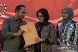 Ketua Bawaslu Jawa Barat Zacky M Zamzam (kiri) menyerahkan surat rekomendasi kepada Ketua KPU Jawa Barat Ummi Wahyuni (tengah) seusai Rapat Pleno Penetapan Daftar Pemilih Tetap (DPT) Pemilihan Gubernur dan Wakil Gubernur Jawa Barat 2024 di Bandung, Jawa Barat, Minggu (22/9/2024). KPU Jawa Barat menetapkan daftar pemilih tetap Pilkada Jawa Barat 2024 berjumlah 35.925.960 orang yang tersebar di 73.862 tempat pemungutan suara di 27 kabupaten/kota Jawa Barat. ANTARA FOTO/Novrian Arbi/agr