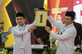 Pasangan calon Wali Kota dan Wakil Wali Kota Pasuruan Adi Wibowo (kiri) dan Muhammad Nawawi (kanan) menunjukkan nomor urut saat Rapat Pleno Terbuka Pengundian dan Penetapan Nomor Urut di Kantor KPU Kota Pasuruan, Jawa Timur, Senin (23/9/2024). KPU Kota Pasuruan menetapkan pasangan calon Wali Kota dan Wakil Wali Kota Pasuruan Adi Wibowo dan Muhammad Nawawi dengan nomor urut satu dan menjadi pasangan calon tunggal dalam Pilkada 2024. Antara Jatim/Umarul Faruq