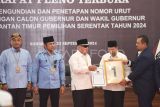 Ketua Komisi Pemilihan Umum (KPU) Provinsi Kalimantan Timur Fahmi Idris (kanan) memberikan nomor urut satu kepada calon gubernur dan calon wakil gubernur Kaltim Isran Noor (ketiga kanan) dan Hadi Mulyadi (kedua kanan) disaksikan calon gubernur Rudy Mas'ud (kedua kiri) dan calon wakil gubernur Seno Aji (kiri) dalam Rapat Pleno Terbuka Pengundian dan Penetapan Nomor Urut Pasangan Pilgub Kaltim 2024 di Kantor KPU Provinsi Kaltim, di Samarinda, Senin (23/9/2024). Pasangan Cagub Kaltim Isran Noor dan Cawagub Hadi Mulyadi mendapat nomor urut satu sedangkan Cagub Rudy Mas'ud dan Cawagub Seno Aji mendapat nomor urut dua. Antara Kaltim/M Risyal Hidayat