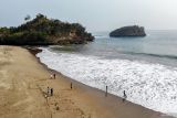 Foto udara pengunjung bermain air di Pantai Ungapan di sekitar Jalur Lintas Selatan, Malang, Jawa Timur, Minggu (22/9/2024). Keberadaan Jalur Lingkar Selatan (JLS) sejauh 50 kilometer di pesisir Malang yang sudah ada sejak tahun 2016 itu kini membawa dampak positif bagi perkembangan sektor pariwasata di kawasan tersebut diantaranya telah resmi dibuka sekitar 33 pantai yang dikelola oleh kelompok masyarakat setempat bersama Perhutani sehingga dapat menunjang perekonomian di wilayah tersebut.. ANTARA Jatim/Muhammad Mada/mas,