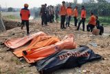 Sejumlah petugas BPBD Kota Bekasi dan polisi berdiri dengan latar depan kantong-kantong berisi tujuh jenazah laki laki yang ditemukan mengambang di Kali Bekasi, Pondok Gede Permai, Jatiasih, Kota Bekasi, Minggu (22/9/2024). Kepolisian masih menyelidiki penyebab kematian tujuh orang tersebut. ANTARA FOTO/Rezas Ale/app/foc.