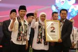 Ketua KPU Jawa Timur Aang Kunaifi (kanan) menyerahkan nomor urut kepada pasangan calon Gubernur dan Wakil Gubernur Jawa Timur Khofifah Indar Parawansa-Emil Elestianto Dardak saat Rapat Pleno Terbuka Pengundian dan Penetapan Nomor Urut Pasangan Calon Gubernur dan Wakil Gubernur Jawa Timur di Surabaya, Jawa Timur, Senin (23/9/2024). KPU Jawa Timur menetapkan pasangan cagub-cawagub Luluk Nur Hamidah-Lukmanul Khakim mendapatkan nomor urut satu, pasangan Khofifah Indar Parawansa-Emil Elestianto Dardak nomor urut dua dan pasangan Tri Rismaharini-Zahrul Azhar Asumta nomor urut tiga. ANTARA Jatim/Moch Asim.